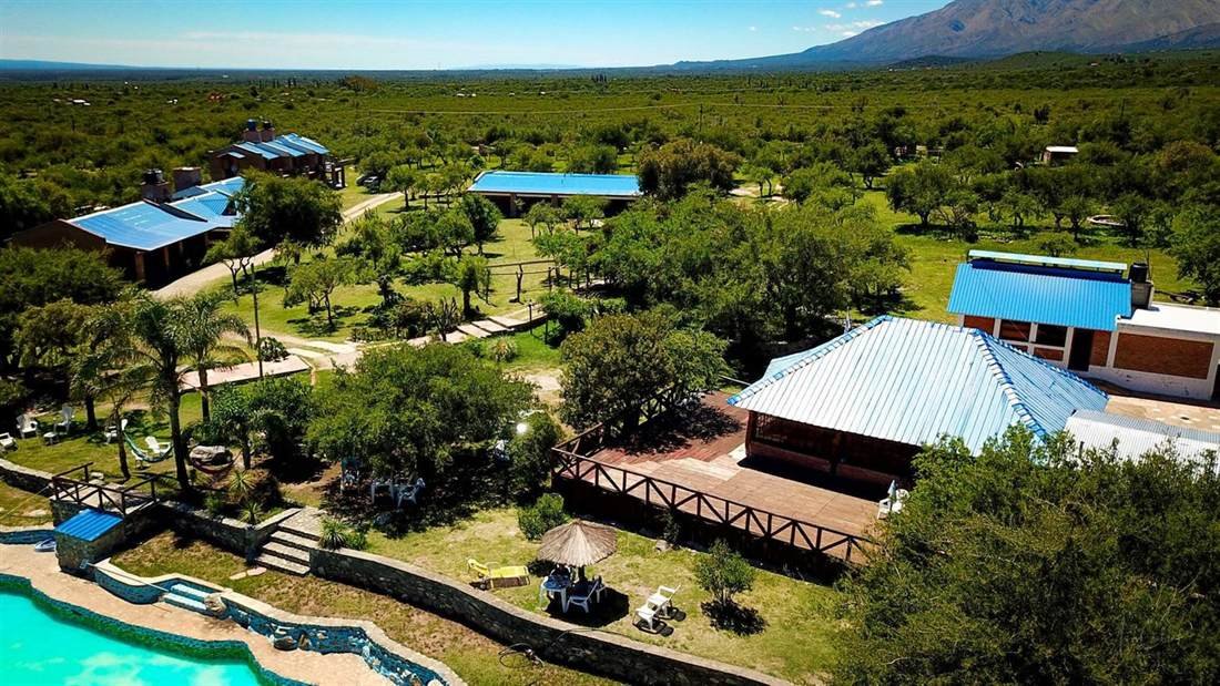 Vista aérea del parque y la piscina con las sierras de fondo en Complejo Laguna Azul, Los Molles, San Luis